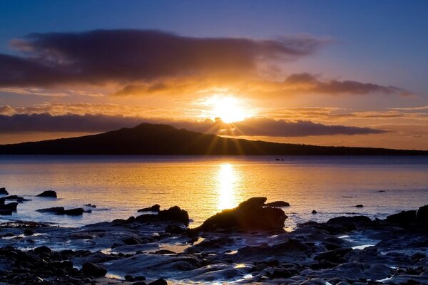 落日在岛上。 石海岸