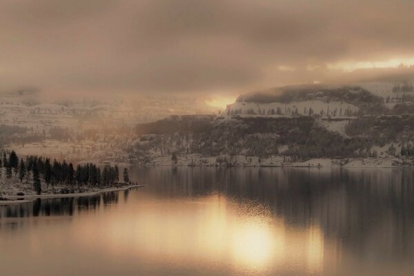 Lago de inverno no fundo do pôr do sol