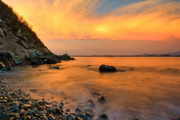 Orange sunset on the rocky seashore