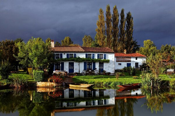 Cottage by the water. Leaden sky before a thunderstorm