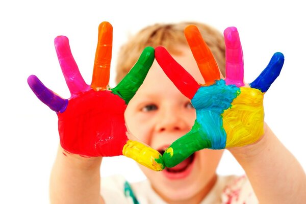 The child painted his hands with multicolored paints