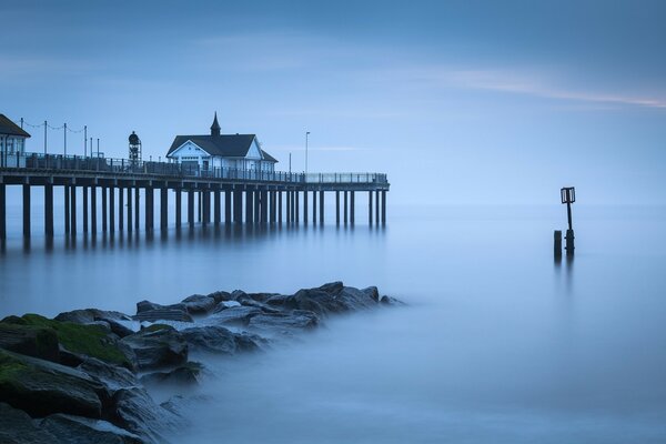 Fog at the pier and a house on the beach