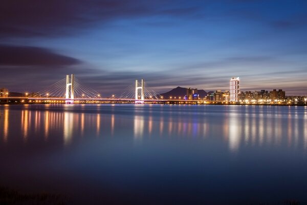 Brücke über den Fluss in der Stadt bei Nacht