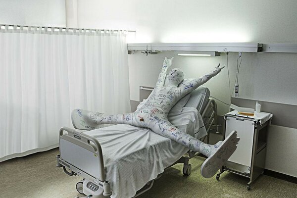 Foto engraçada com um homem em uma cama de hospital com gesso