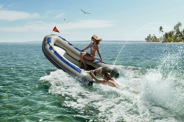 A guy in a mask pushes a boat with a girl