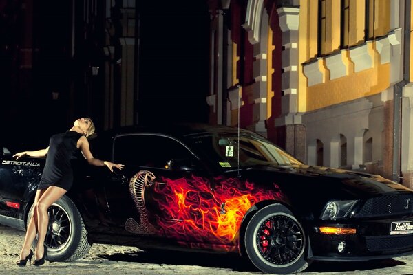 A girl near a black sports car