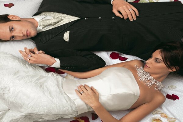 The bride and groom are lying on a white background