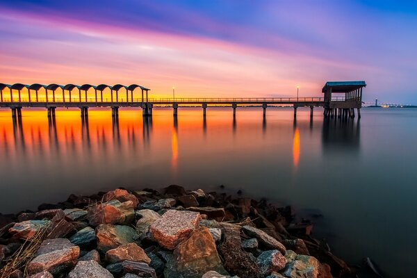 Sonnenuntergang am Meer. Pier und Strand