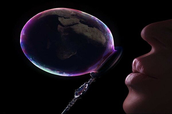 A woman inflates a soap bubble through a tube