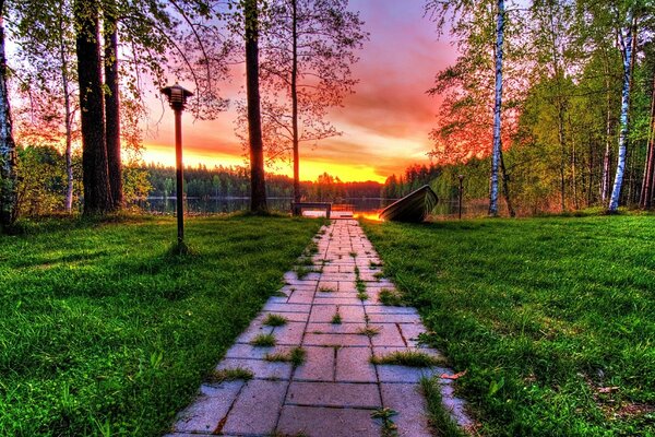 Sunset on the lake in the park. Trail and lantern