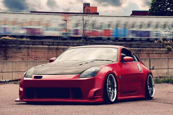 Red car with tuning at the fence