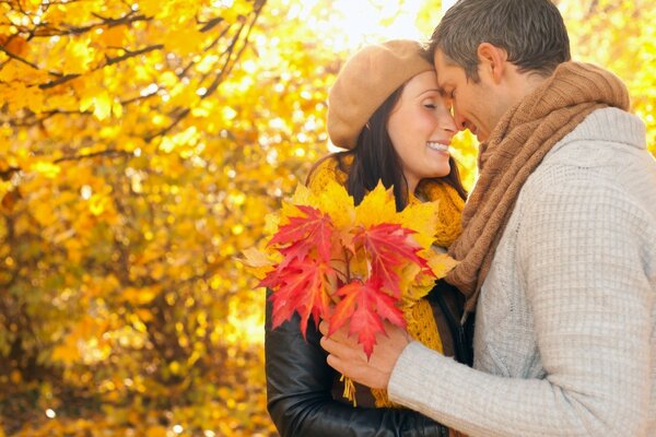 A couple in love in autumn in a park with maple leaves