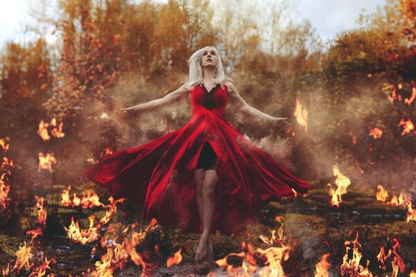 A girl in a red dress among the fire