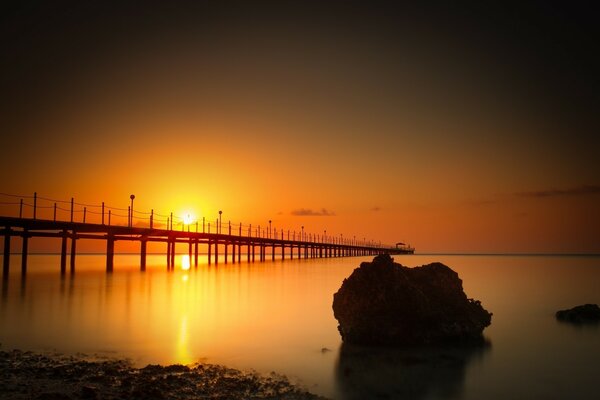 Landschaft der langen Brücke bei Sonnenuntergang über der Wasseroberfläche