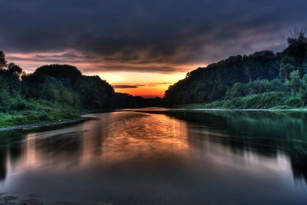 Fiume contro il cielo nuvoloso al tramonto