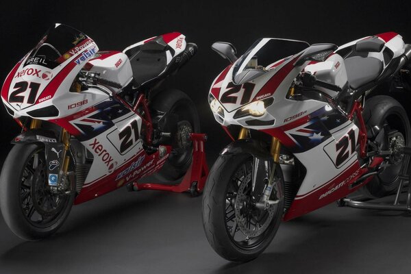 Two sports motorcycles on a dark background