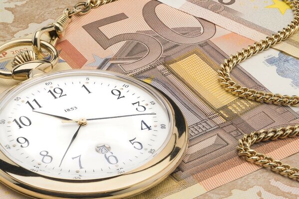 Une montre en or se trouve sur un billet d argent