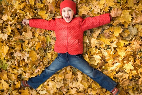 A child in the park on maple leaves