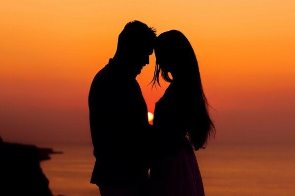 Couple d amoureux au coucher du soleil au bord de la mer