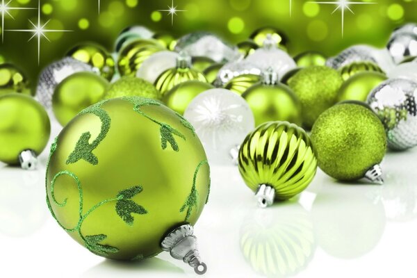 Grüne und silbrige Weihnachtskugeln auf weißem Hintergrund