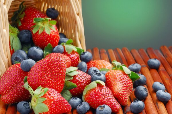 Erdbeeren und Blaubeeren wurden aus dem Korb geschüttet