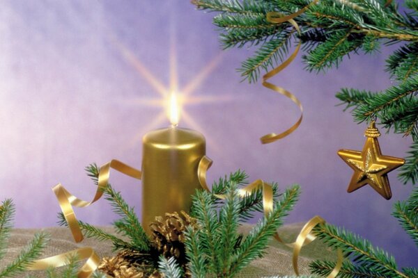 A yellow candle on the table near a fir tree