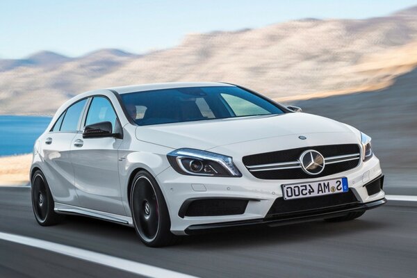 Un Mercedes blanco vuela por la carretera