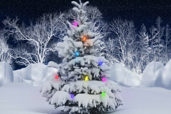 A snow-covered Christmas tree with a burning garland in the middle of a snow-covered forest at night