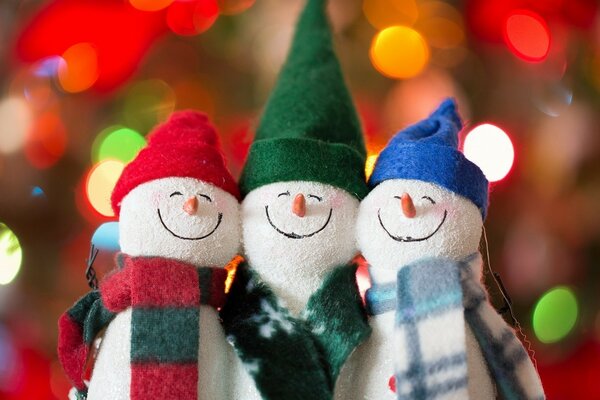 Three funny snowmen with hats of different colors