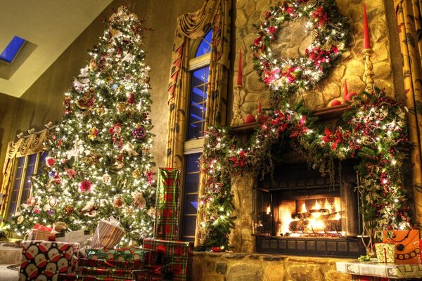 Decoración navideña de la casa con chimenea y árbol alto en juguetes