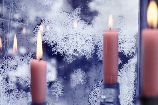 Velas Rosadas iluminadas sobre un fondo de vidrio congelado