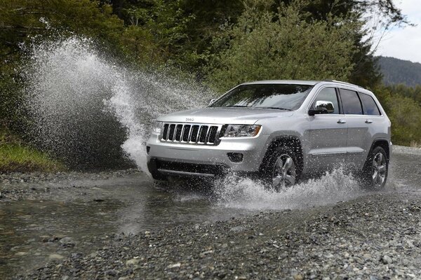 Un SUV argenté traverse la rivière