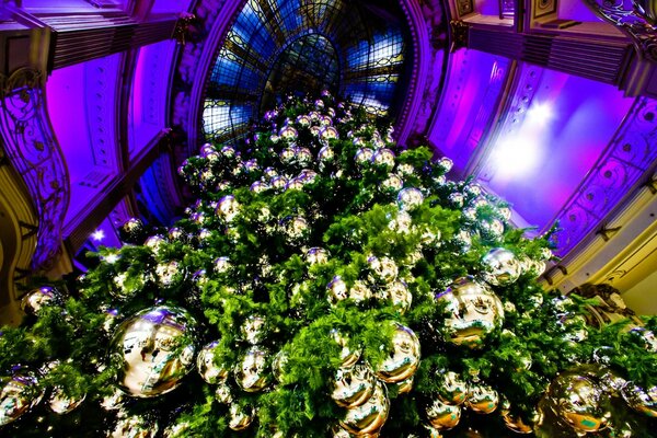 Photo of a Christmas tree decorated with golden balls from below