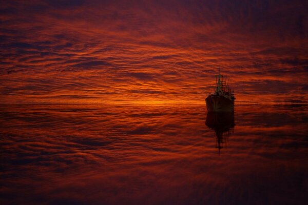 Das Schiff schwimmt in einem purpurnen Sonnenuntergang