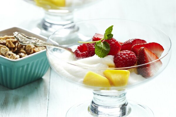 Mousse sucrée avec des noix et des morceaux de fraises dans un verre Crémant