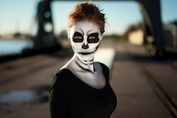 Halloween-Mädchen mit Make-up auf der Brücke