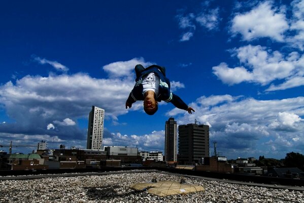 Ein Parkour-Typ führt einen backflip auf dem Dach aus