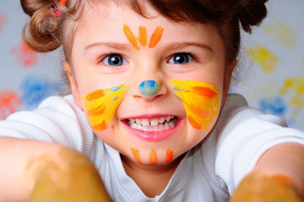 A cheerful girl painted herself with paints