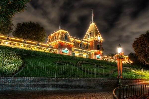 House with illumination behind an iron fence