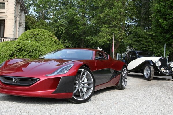 Photo of a sports car on the background of a vintage car