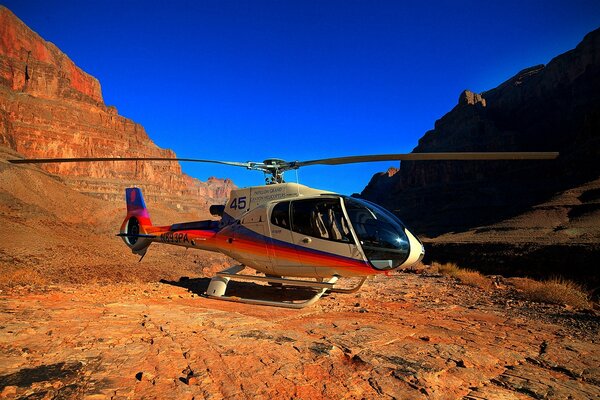 A small beautiful helicopter in the rocks