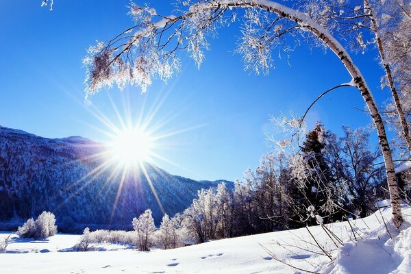 Le soleil se lève de derrière les montagnes en hiver