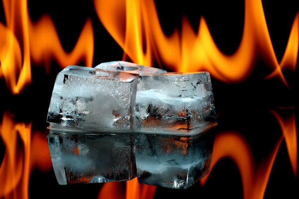 Cubitos de hielo en el vidrio en el fondo de la llama