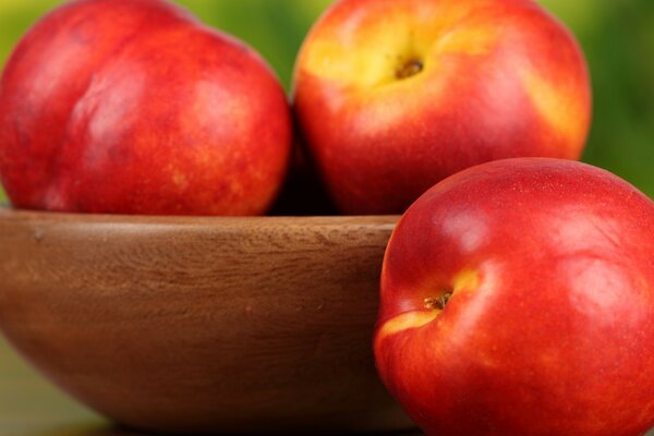 Deliciosas manzanas en un tazón de madera