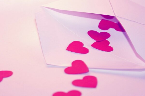 An envelope with hearts on a white table