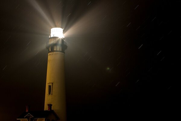 The light of the lighthouse illuminates the dark night