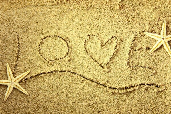 Love inscription on the beach sand