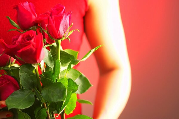 Mädchen im roten Kleid mit einem Strauß roter Rosen