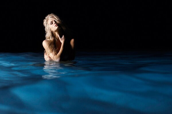 Blonde in the water in the twilight