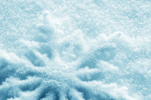 A pattern on the snow made in the shape of a snowflake